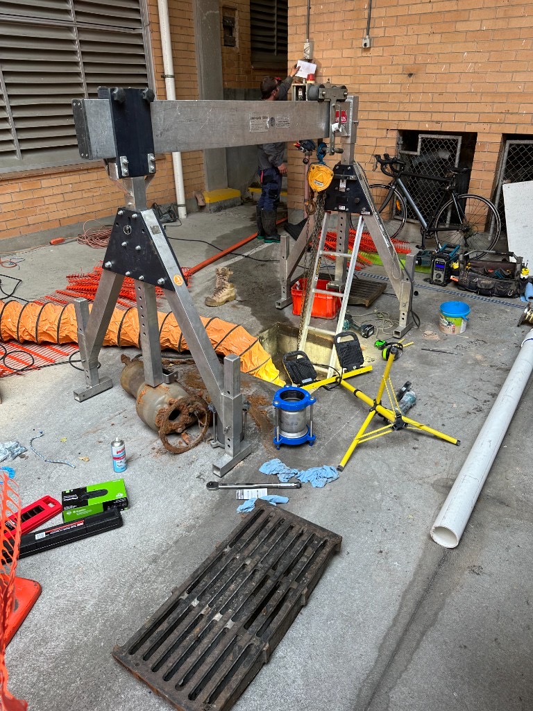 Portable aluminium gantry crane and chain hoist set over the Queen Victoria Apartments pump pit during extraction of a failed 210 kg stormwater pump